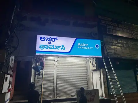 Glow sign board being installed on a pharmacy at night